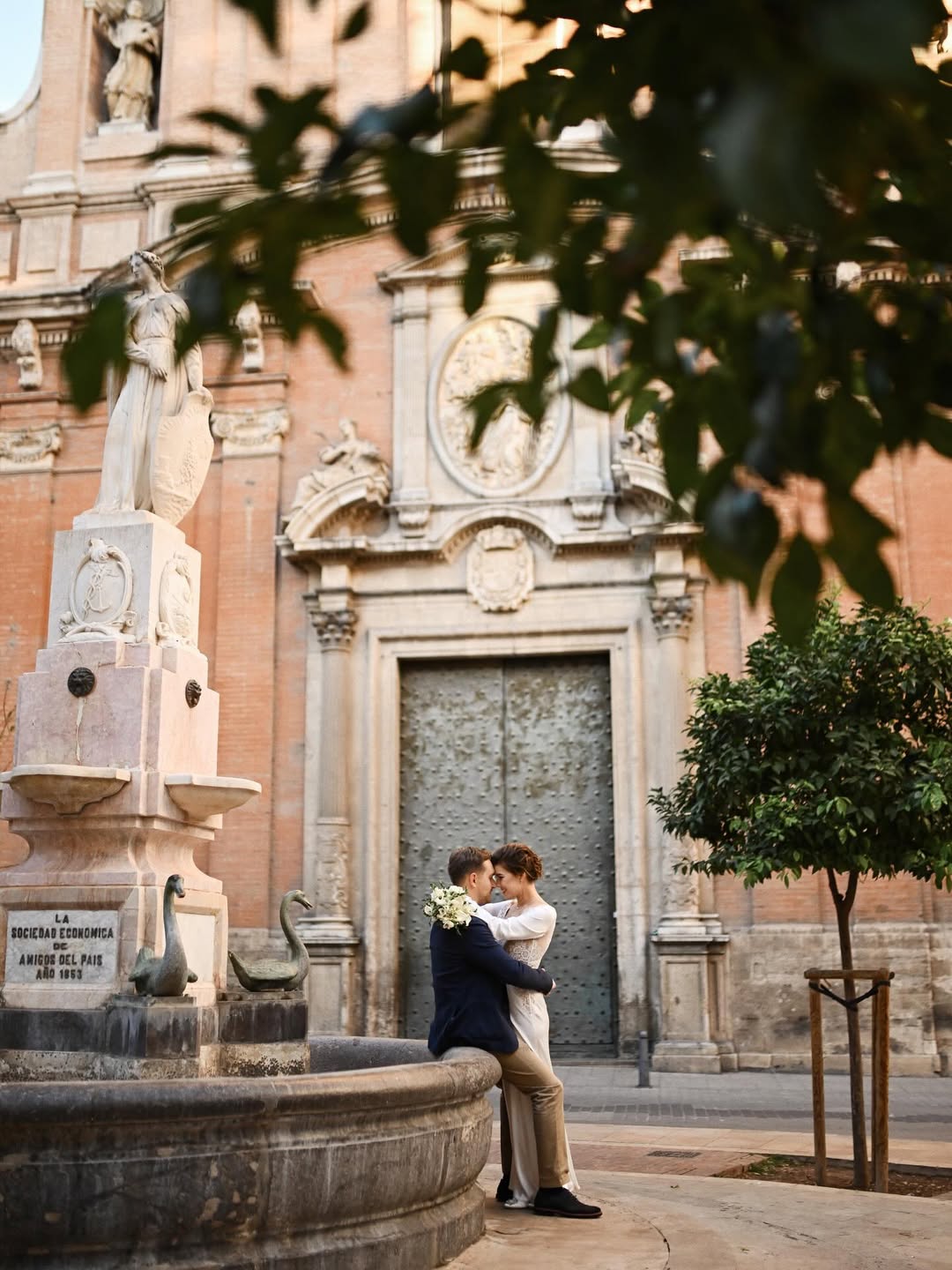 A stylish bride and groom walking hand-in-hand through the narrow historic streets of Valencia's Old Town. Timeless wedding photography with a European city vibe. ⠀